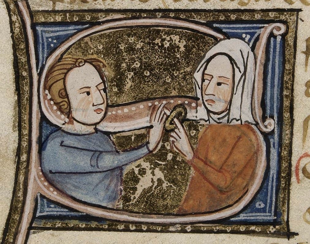 Happy Middle Ages Couple. Husband putting a golden wedding Ring on his new wife’s hand. They might need to get it resized!